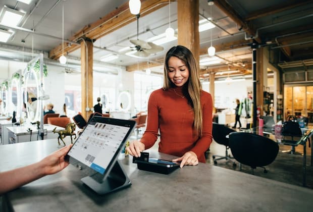 Independent retailer completing a customer sale at a shop counter