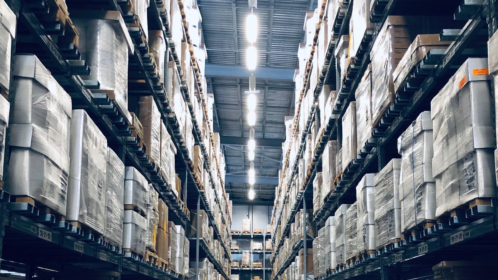 Wide aisle of a wholesale distribution warehouse stacked with palletised inventory