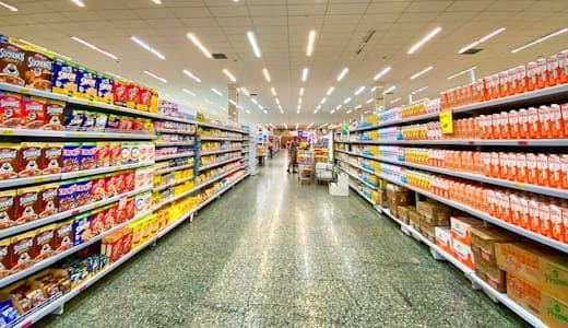 Retail aisle lined with stocked shelves of consumer packaged goods